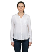 Woman wearing a white shirt and dark jeans on a white background