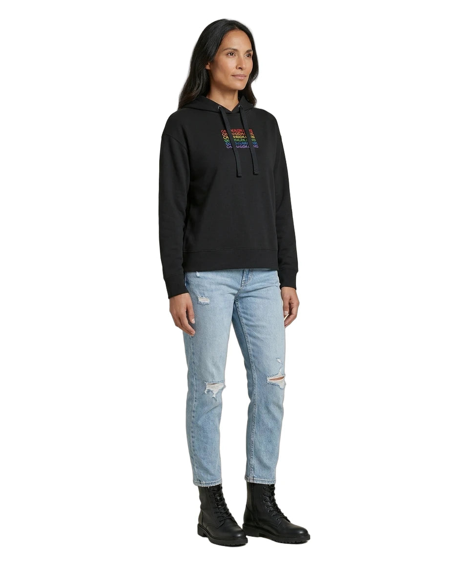 Woman wearing a black Calvin Klein hoodie with colorful text design on a white background