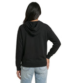 Woman wearing a black Calvin Klein hoodie with colorful text design on a white background seen from the back