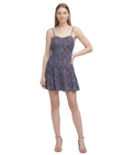 Woman wearing a floral Calvin Klein dress on a white background