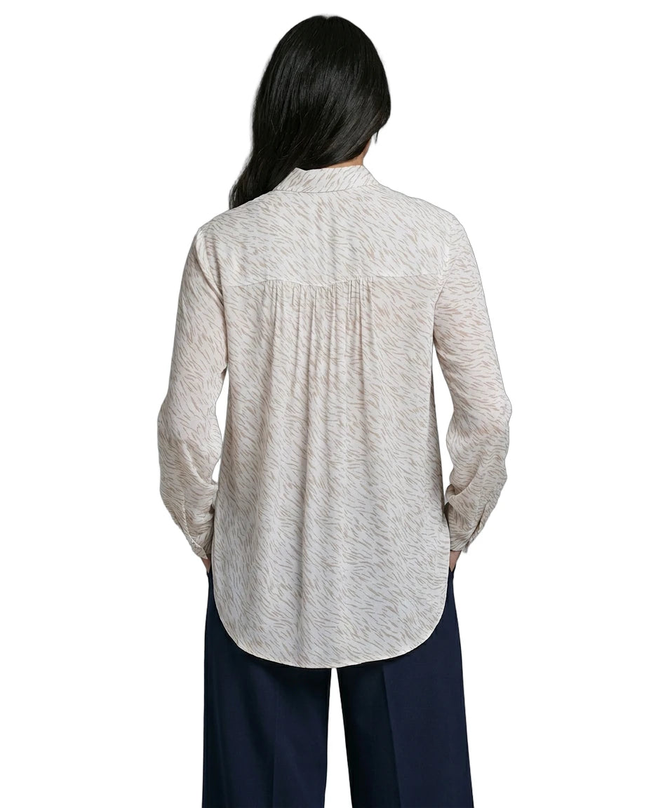 Person wearing a light gray button-up Calvin Klein shirt and dark pants on a white background