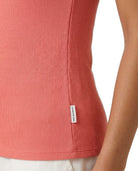 Close-up of a coral ribbed top with a Calvin Klein brand label on a white background