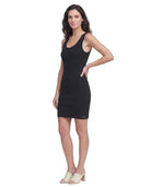 Woman wearing a black sleeveless Calvin Klein dress on a white background