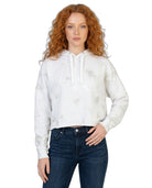 Woman wearing a white tie-dye Calvin Klein hoodie and blue jeans on a white background