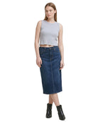 Woman wearing a gray sleeveless Calvin Klein top and blue denim skirt on a white background