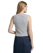 Woman wearing a sleeveless gray Calvin Klein top and dark blue denim skirt on a white background