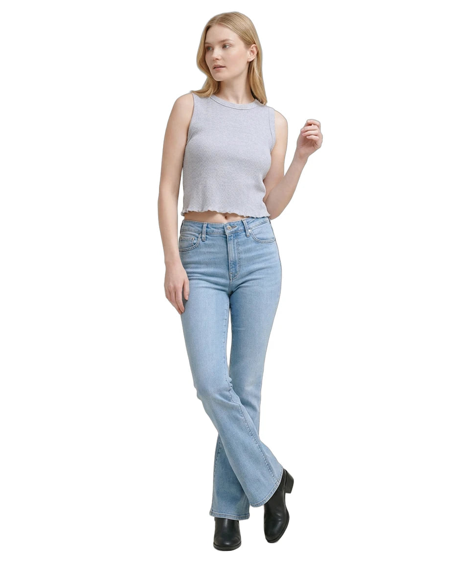 Woman wearing a light gray sleeveless top and blue jeans on a white background