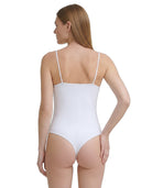 Woman wearing a white Calvin Klein bodysuit with thin straps on a plain background
