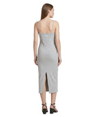 Woman wearing a gray Calvin Klein dress with a slit on a white background