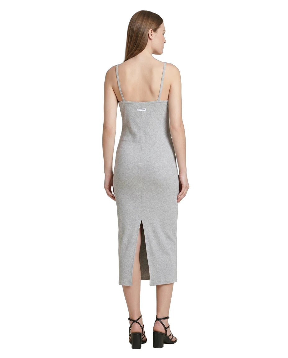 Woman wearing a gray Calvin Klein dress with a slit on a white background