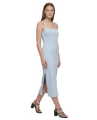 Woman wearing a light blue Calvin Klein dress on a white background