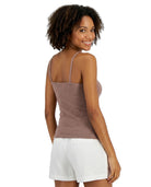Woman wearing a brown Calvin Klein tank top and white shorts on a white background