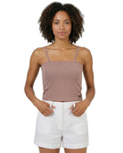 Woman wearing a brown Calvin Klein tank top and white shorts on a white background