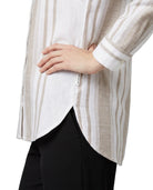 Close-up of a person wearing a striped Calvin Klein shirt with a white background