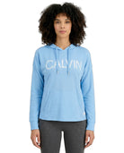 Woman wearing a light blue Calvin Klein hoodie on a white background