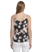 Woman wearing a floral camisole top on a white background