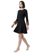Black Calvin Klein dress with leopard print cuffs worn by a model on a white background
