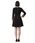 Black Calvin Klein dress with leopard print cuffs worn by a model on a white background