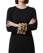 Person wearing a black Calvin Klein dress with leopard print cuffs on a white background