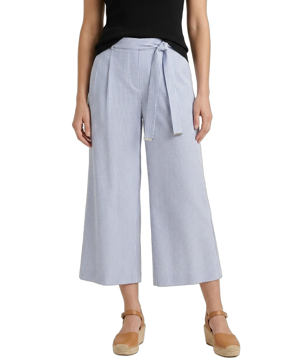 Woman wearing light blue striped wide-leg pants with a belt on a white background