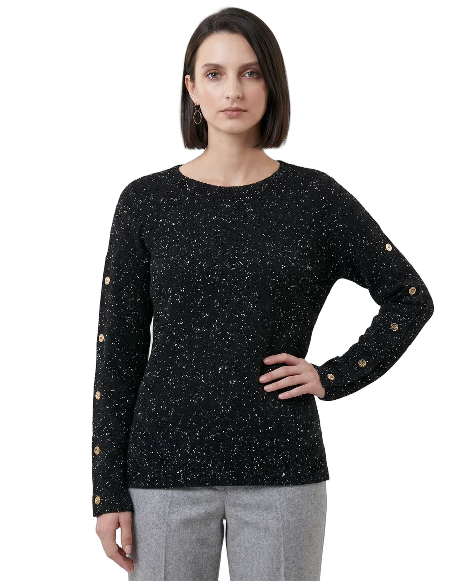 Woman wearing a black speckled sweater with gold buttons on a white background