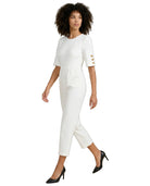 Woman wearing a white dress with gold buttons on a white background