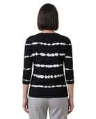 Person wearing a black and white striped sweater on a white background