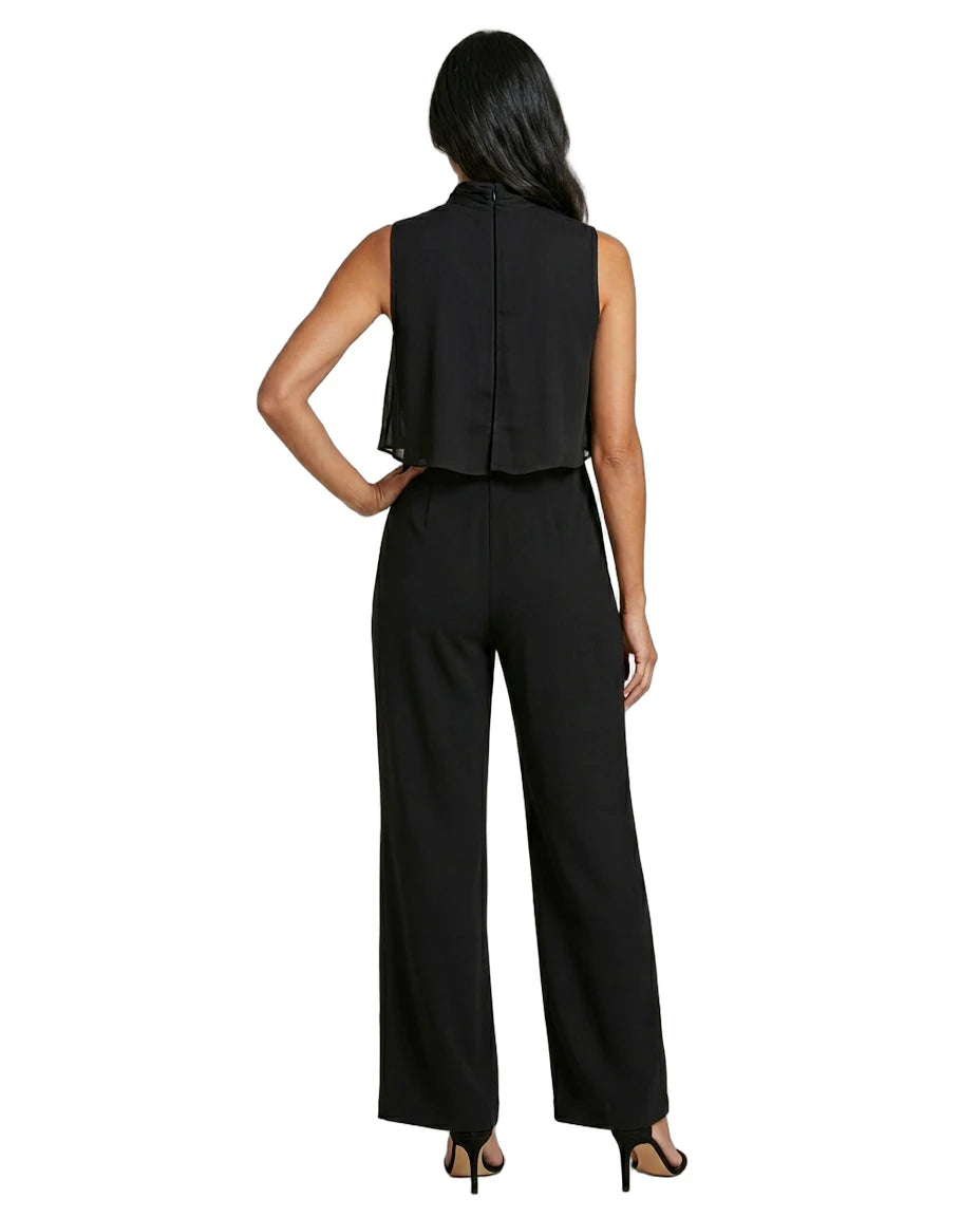 Woman wearing a black sleeveless top and wide-leg pants on a white background