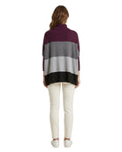Woman wearing a striped Calvin Klein sweater with a white background