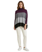 Woman wearing a striped Calvin Klein sweater and white pants on a white background