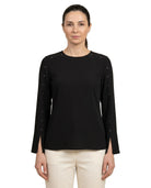 Woman wearing a black long-sleeve top with decorative elements on a white background