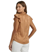 Woman wearing a brown Calvin Klein blouse with ruffled details on a white background