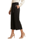 Person wearing black Calvin Klein wide-leg pants with a belt on a white background