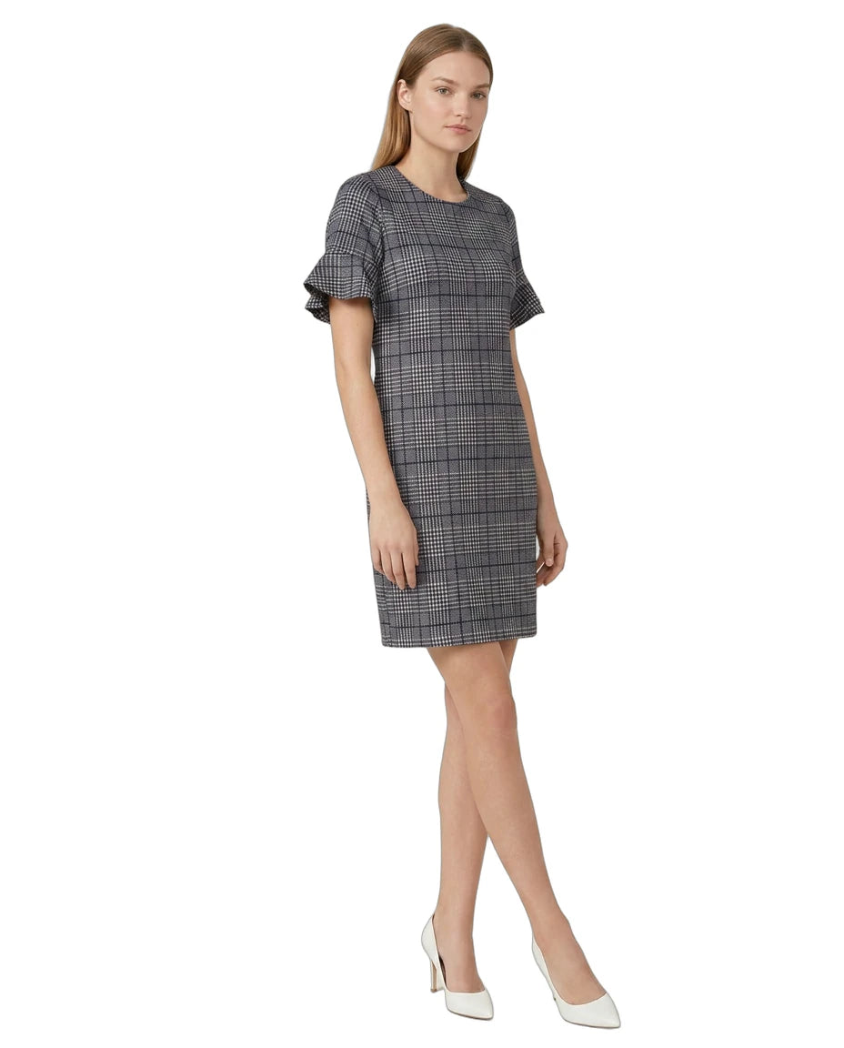 Woman wearing a  Calvin Klein gray checkered dress with ruffled sleeves on a white background