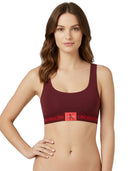 Woman wearing a maroon Calvin Klein bralette on a white background