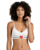 Woman wearing a Calvin Klein bralette on a white background
