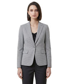 Woman wearing a gray Calvin Klein blazer over a black top on a white background