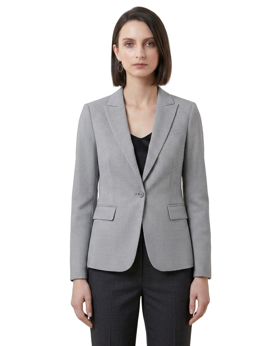 Woman wearing a gray Calvin Klein blazer over a black top on a white background
