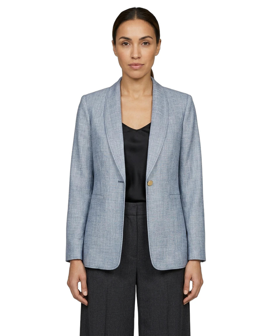 Woman wearing a light blue Calvin Klein  checkered blazer over a black top on a white background