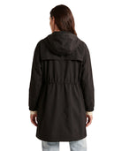 Woman wearing a black Calvin Klein coat viewed from the back, white background