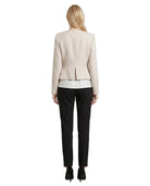 Woman wearing a Calvin Klein beige blazer and black pants on a white background