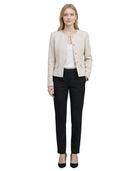 Woman wearing a Calvin Klein beige blazer and black pants on a white background