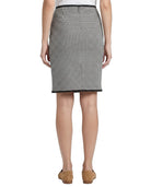 Person wearing a Calvin Klein houndstooth patterned skirt on a white background