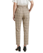 Person wearing Calvin Klein beige checkered pants on a white background