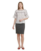 Woman wearing a Calvin Klein checkered blouse and gray skirt on a white background