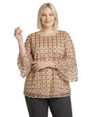 Woman wearing a beige patterned Calvin Klein blouse on a white background