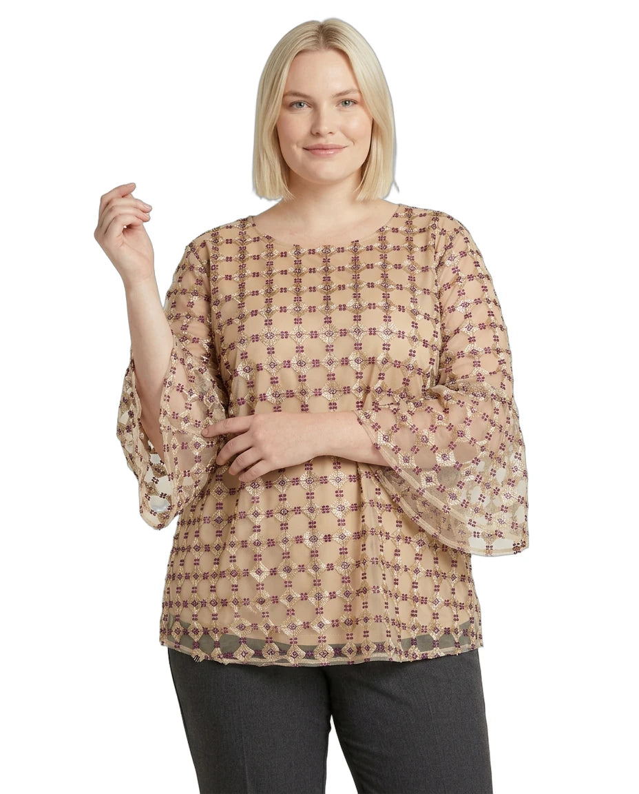 Woman wearing a beige patterned Calvin Klein blouse on a white background