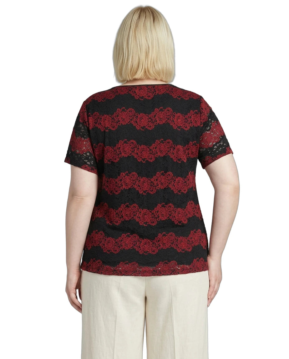 Woman wearing a black and red patterned top with beige pants on a white background