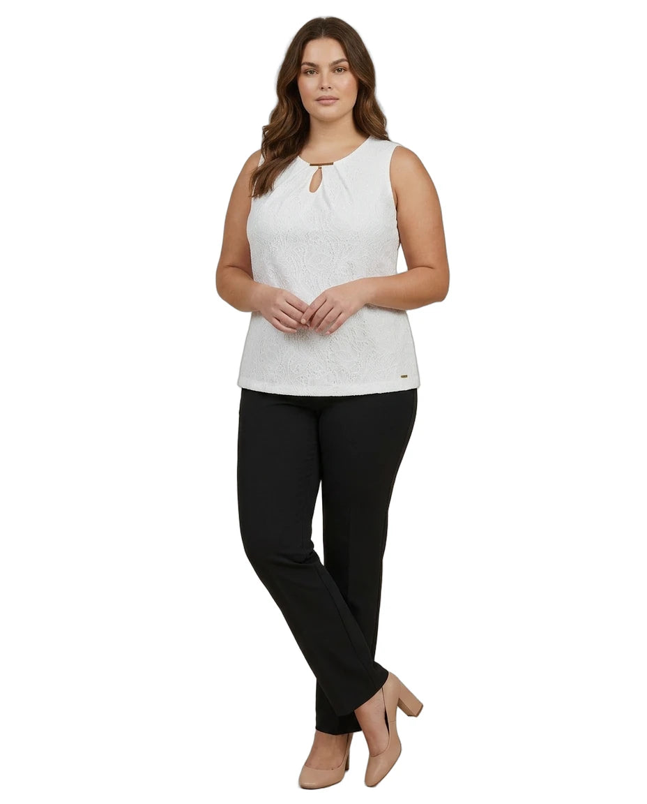 Woman wearing a white sleeveless Calvin Klein top and black pants on a white background