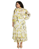 Woman wearing a Calvin Klein floral dress with sheer sleeves on a white background